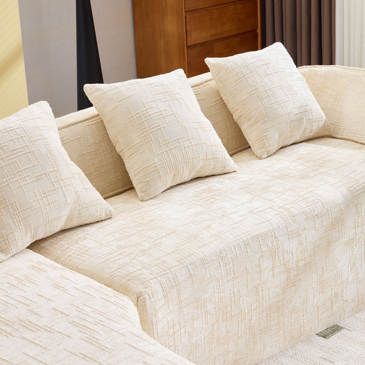 Beige L-Shaped Sofa with Curved Armrests and Throw Pillows